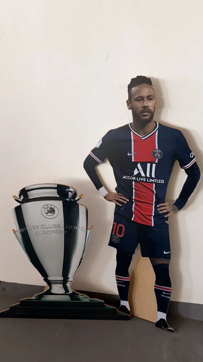 Jogador de futebol e troféu em painel